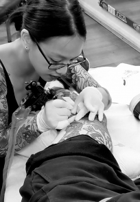 Valérie Mehong tattooing a client